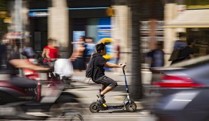 E-scooter navigating traffic, illustrating challenges in urban mobility integration